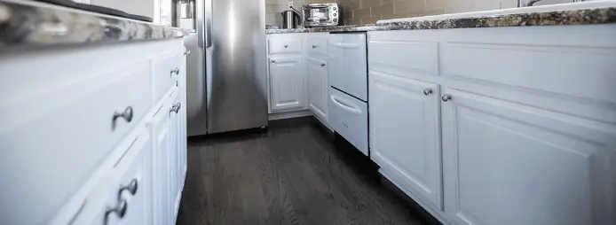 White painted kitchen cabinets with dark countertops