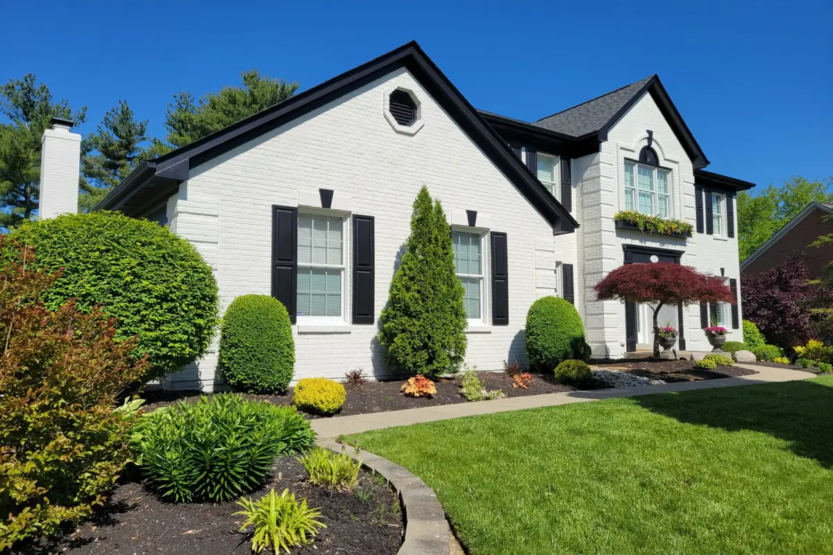 White two-story home with black shutters after an exterior repaint