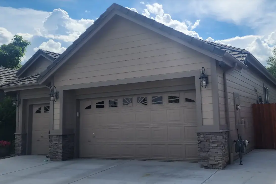 Taupe home and garage doors with dark trim after an exterior repaint