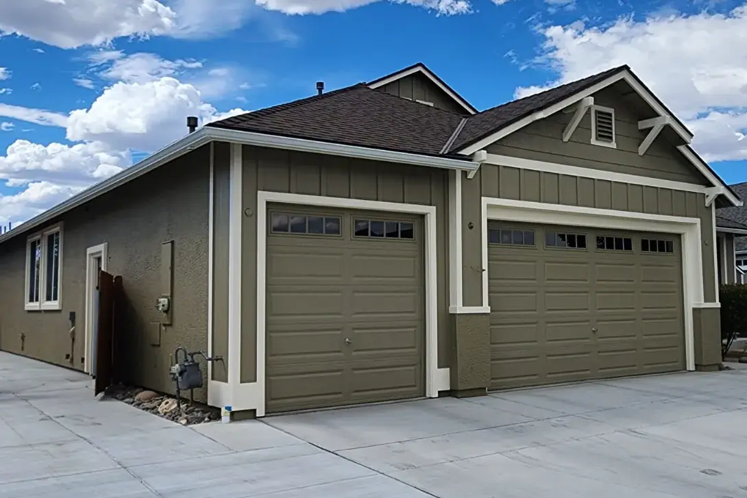 Olive-green garage and home exterior with white trim after painting